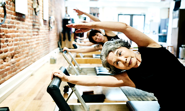 Woman using the wall to stretch in a physical fitness class
