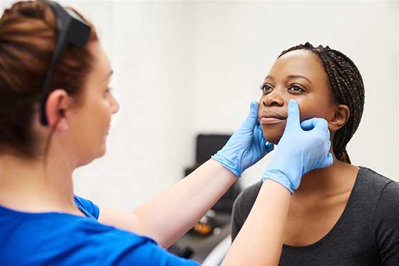 Woman being checked by dermatologist