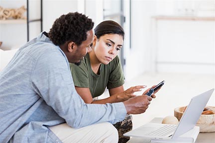Man and woman discussing what to buy at a kitchen table