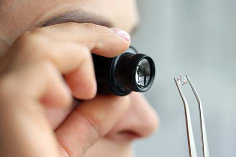 Man looking at a diamond thru a loop