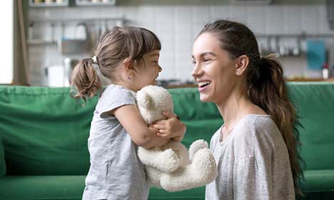 Mom with daughter hugging a Teddy Bear